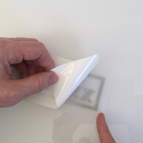 Aufkleber anbringen: Aufkleber umdrehen und Trägerpapier entfernen